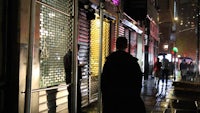 a man walking down a city street at night