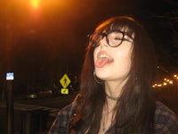 a woman with glasses is sticking her tongue out